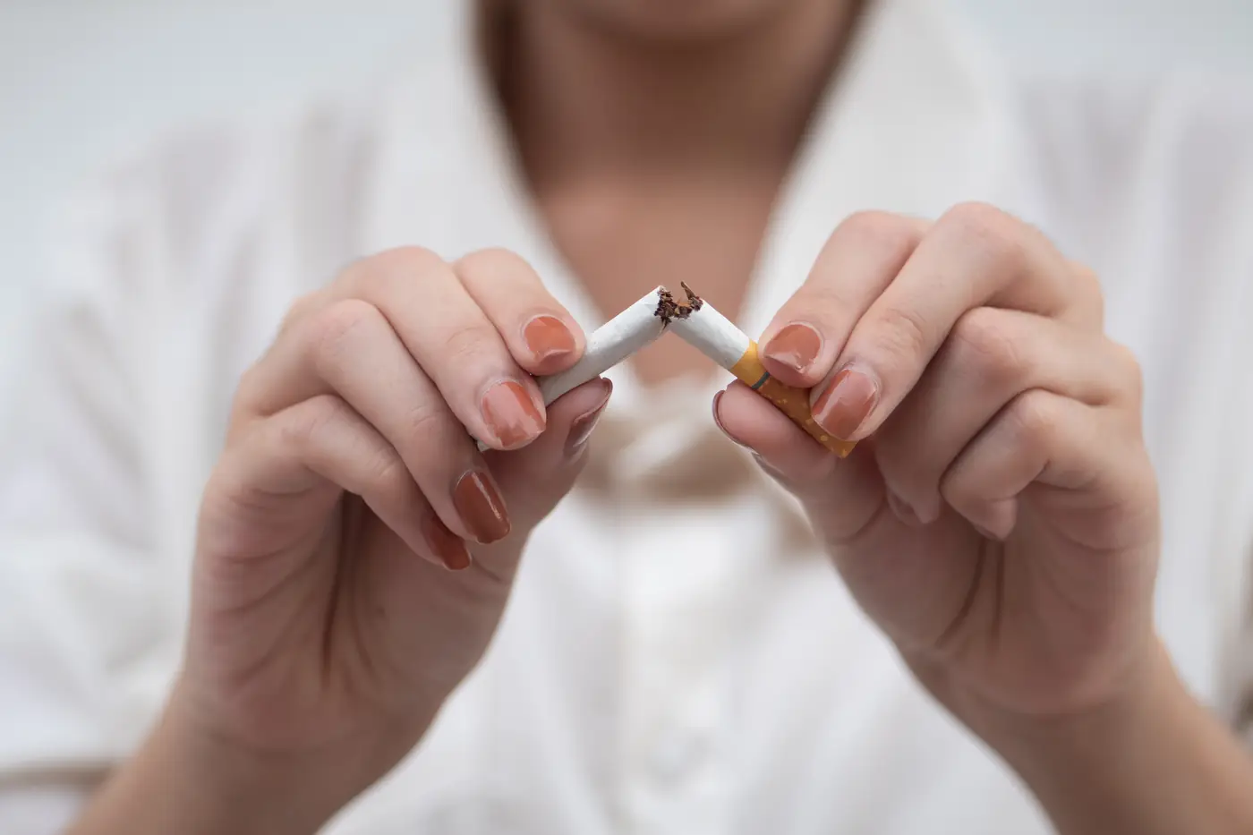 Hands snapping a cigarette in half