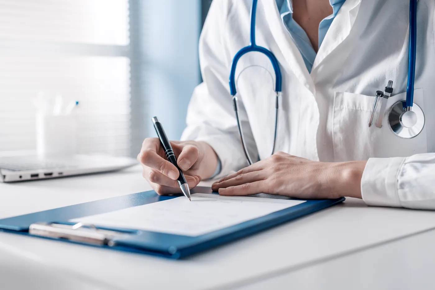 Doctor writing a prescription on a clipboard